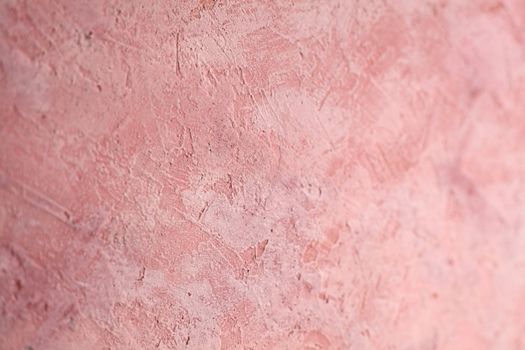 Concrete pink background with scuffs and splashes. Textured wall texture in the grunge style with soft focus. Space for text