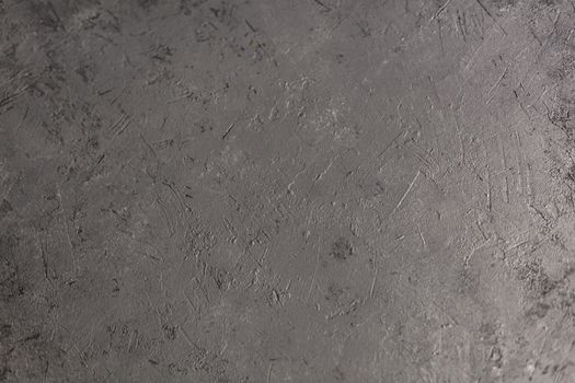 Concrete dark gray background with scuffs and splashes. Textured wall texture in the grunge style with soft focus. Space for text