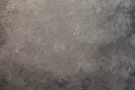 Concrete dark gray background with scuffs and splashes. Textured wall texture in the grunge style with soft focus. Space for text
