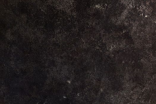Concrete dark gray background with scuffs and splashes. Textured wall texture in the grunge style with soft focus. Space for text