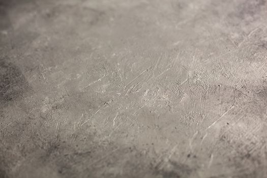 Concrete dark gray background with scuffs and splashes. Textured wall texture in the grunge style with soft focus. Space for text
