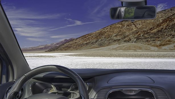 Looking through a car windshield with view of Badwater Basin, the lowest elevation point in USA, Death Valley National park in California