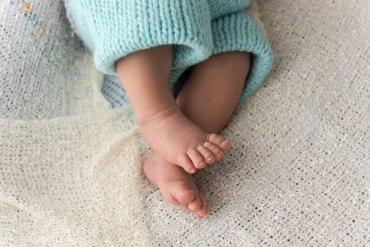 Closeup of a newborn baby feet with beautiful selective focus. Concept for maternity and tenderness