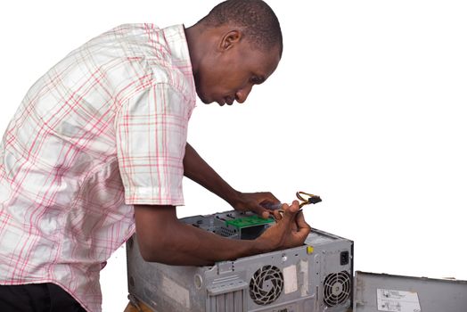 young technician standing over a desk repairing the computer