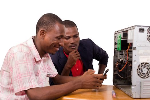 two technicians sitting at the desk working together on a computer