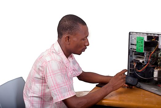 Young technician working on broken computer in his office
