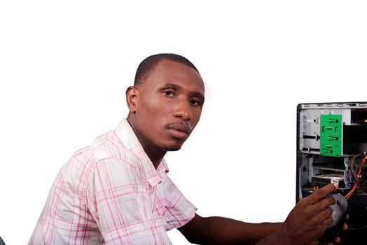 Young technician working on broken computer in his office