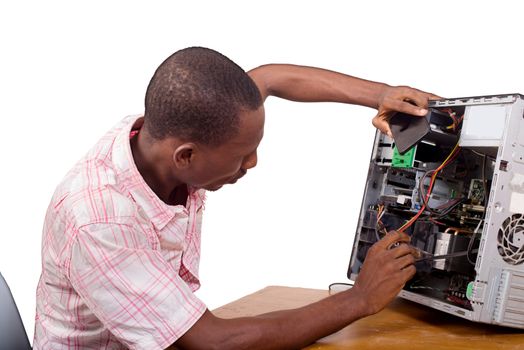 Young technician working on broken computer in his office