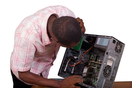 Young technician working on broken computer in his office