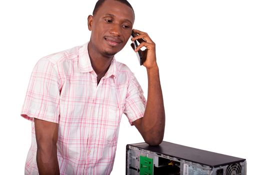 young computer scientist talking on the phone standing against a computer