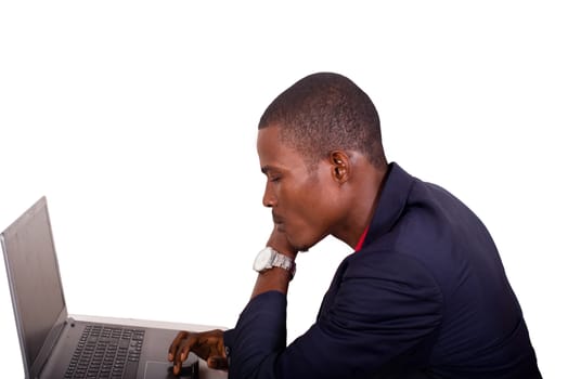 .Young businessman working on his laptop in the office. Young african executive sitting at his desk, surfing the internet on laptop.