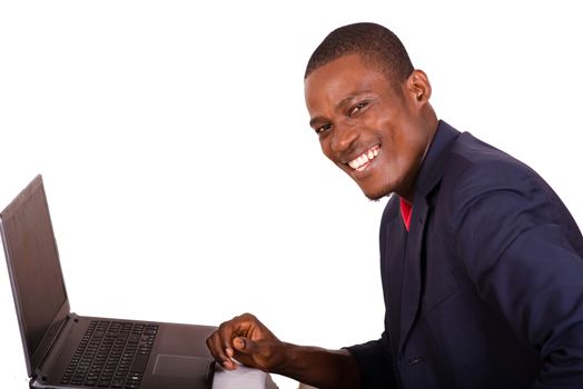 Young happy man executive in suit working on laptop at his desk.