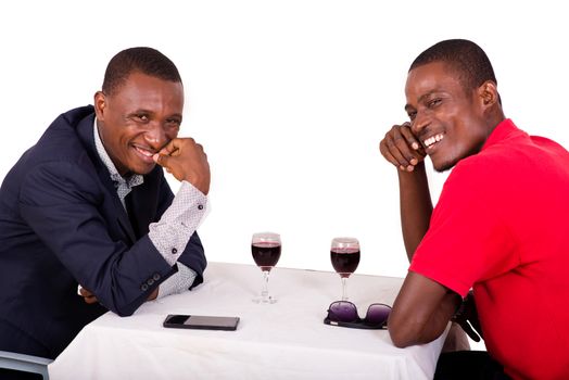 young happy businessmen talking business while drinking wine at table