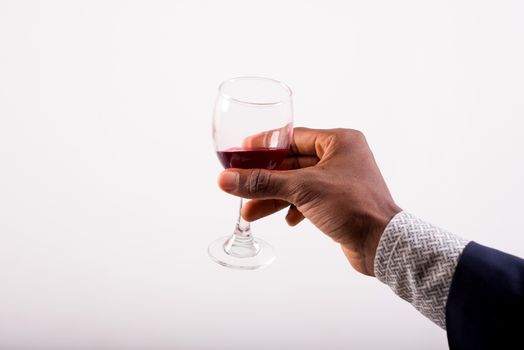 Glasses of red wine in their hand of a man in a suit. The concept of celebration and celebration.