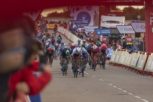 Cyclists from different teams, pedaling hard in the final sprint, in the area of the finish line of the fourth stage of La Vuelta a España 2020.