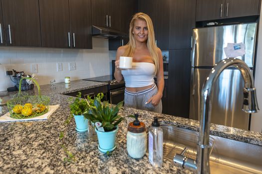 A gorgeous blonde model prepares a meal before heading to work