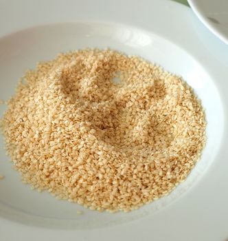 raw sesame to be put on close-up bagels, lots of dried sesame on the plate,