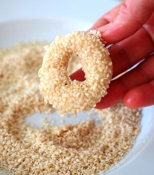 Close-up sesame seeds stuck to the dough, tiny bagels with sesame seeds,