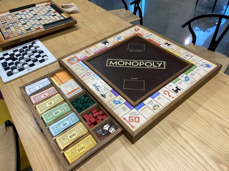 Orlando,FL/USA-10/20/20: A wooden  Monopoly game board, by Hasbro,  with the game pieces in a wooden drawer on a table.
