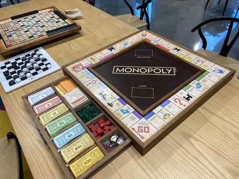 Orlando,FL/USA-10/20/20: A wooden  Monopoly game board, by Hasbro,  with the game pieces in a wooden drawer on a table.