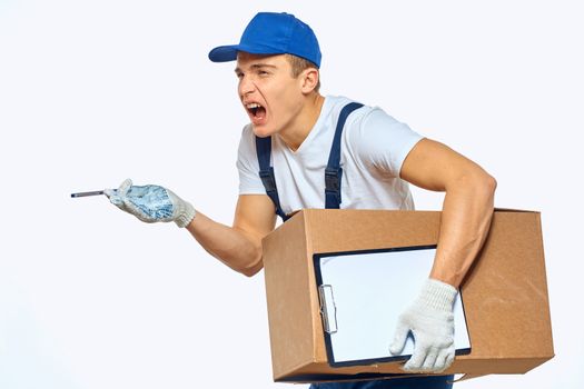 Man worker with box in hands delivery loading service work light background. High quality photo