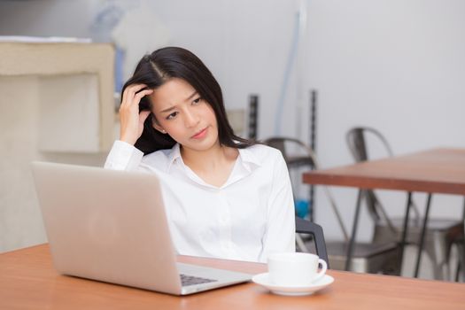 Beautiful young asian woman working and thinking with problem to stress and unhappy, businesswoman with laptop computer on table with emotion, freelance business concept.