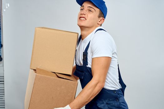working man in uniform with boxes in his hands delivery loader lifestyle. High quality photo