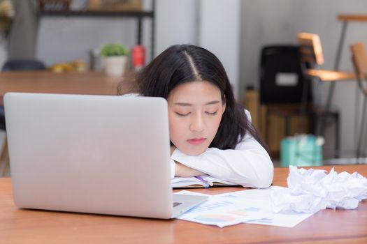 Asian woman with tired overworked and sleep, girl have resting while work writing note, business freelance concept.