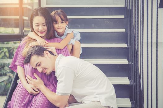 man is listen pregnant of wife, asian handsome father take care mother and kid with couple and expect maternity have a happy, love of family concept.