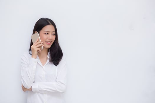 Beautiful young asian woman talking mobile phone and smile standing on cement background, freelancer female calling telephone, communication concept.