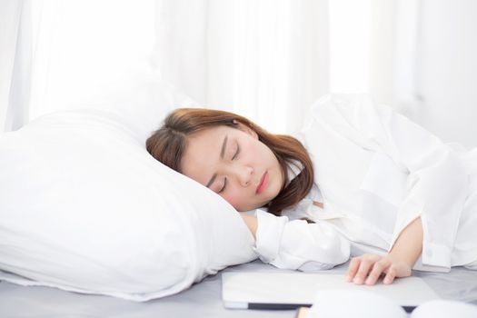 Beautiful young asian woman with laptop lying down in bedroom, girl tired sleep with computer notebook, resting and healthcare concept. 