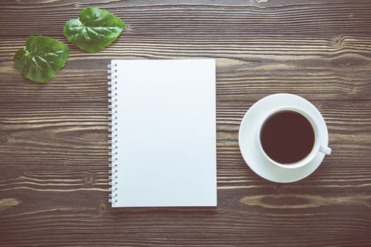 Bouquet of flower and empty diary notebook and a cup of coffee on rustic wooden table with copy space, mockup template with flower and note, top view, vintage retro style.