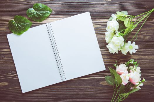 Bouquet of flower and empty diary notebook on rustic wooden table with copy space, mockup template with flower and note, top view, vintage retro style.