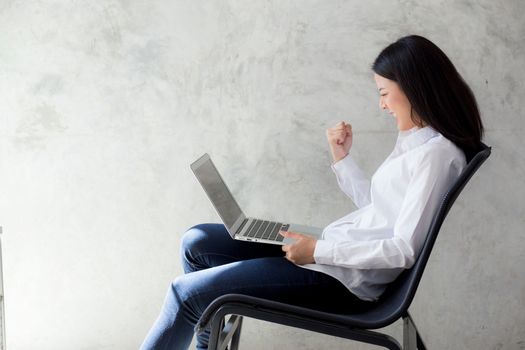 Beautiful asian young woman excited and glad of success with laptop, girl working coffee shop on cement background, career freelance business concept.
