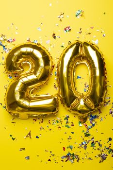 Number 20 from golden foil balloon and confetti stock photo