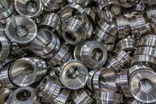 a pile of shiny metal cnc aerospace funnel shape parts production - close-up with selective focus for full frame industrial background