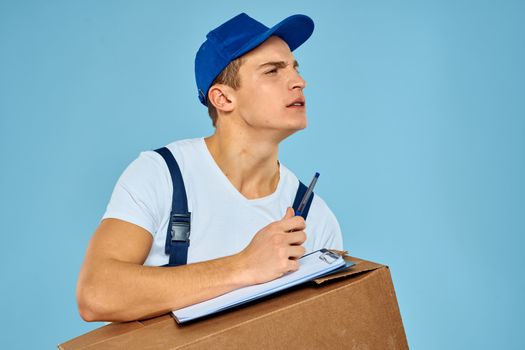 Man worker with cardboard box delivery loader lifestyle blue background. High quality photo