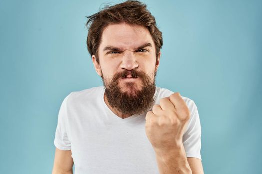 Man with disgruntled facial expression gesturing with hands studio lifestyle blue background. High quality photo