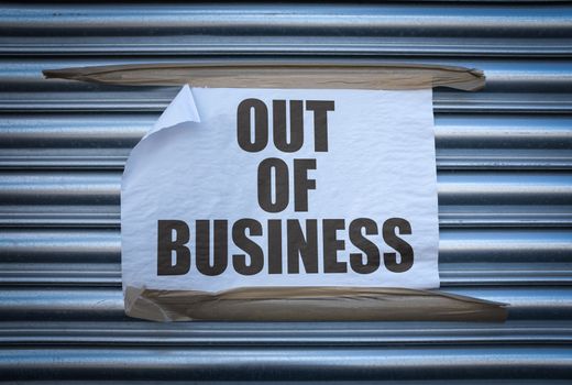 Grungy Out Of Business Sign On Some Old Store Shutters, A Consequence Of The 2020 COVID Pandemic