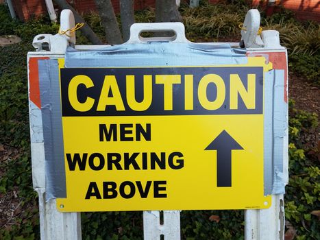 yellow caution men working above sign with arrow