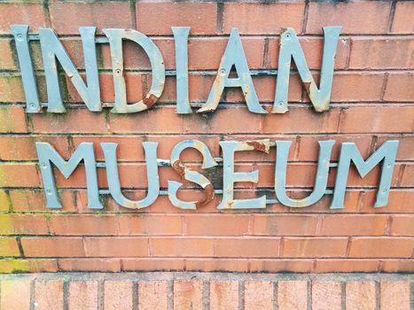 indian museum sign on red brick wall or masonry