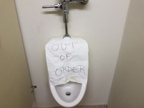 paper out of order sign on bathroom or restroom urinal