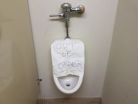 paper out of order sign on bathroom or restroom urinal