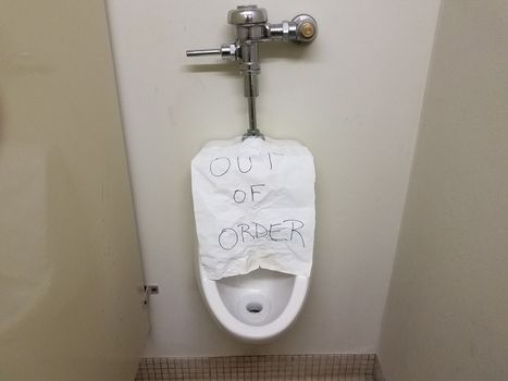 paper out of order sign on bathroom or restroom urinal
