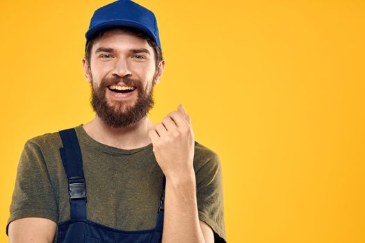 Worker man in uniform worker service yellow background emotion. High quality photo