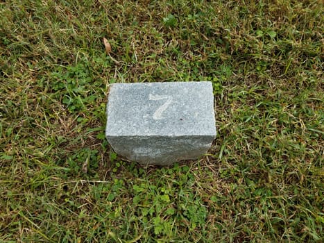 grey stone with number seven in green grass