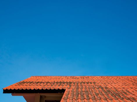 The roof tiles of the building have a background of blue skies of bright sky.