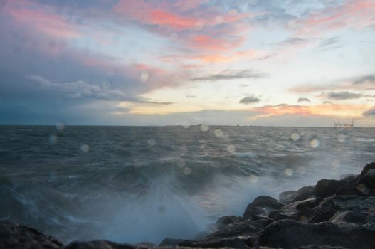 Dramatic splashing ocean wave in the evening with twilight sky in Winter at breakwater at St Kilda pier in Melbourne Australia