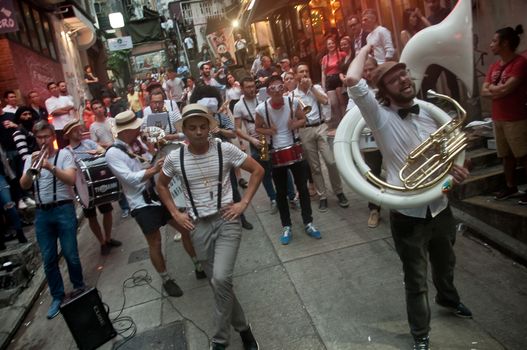 HONG KONG, HONG KONG SAR - NOVEMBER 17, 2018: Local French musician s gathers to play music for mini concert in Lan Kwai Fong Alley in the evening. There are many people in the scene.