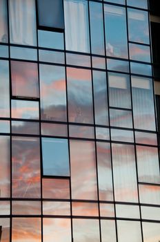 Reflection of pastel Sun set on window glass of modern corporate office building